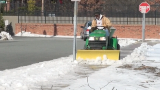 Physical Plant gardener, Scott Rivera, clears a sidewalk.