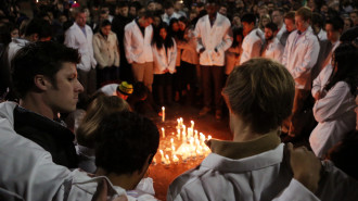UNC Dental students put their arms around each other as they surround a candle memorial for the killed UNC Dental student following a candlelight vigil on the campus of the University of North Carolina at Chapel Hill on Wednesday, February 11, 2015 in Chapel Hill, N.C. Photo by Al Drago
