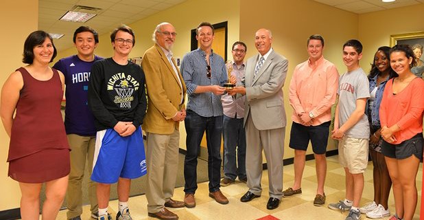 Mitch Pittman ’09 (center) presents Communications Dean Paul Parsons with one of his Emmy Award statues in April 2016.